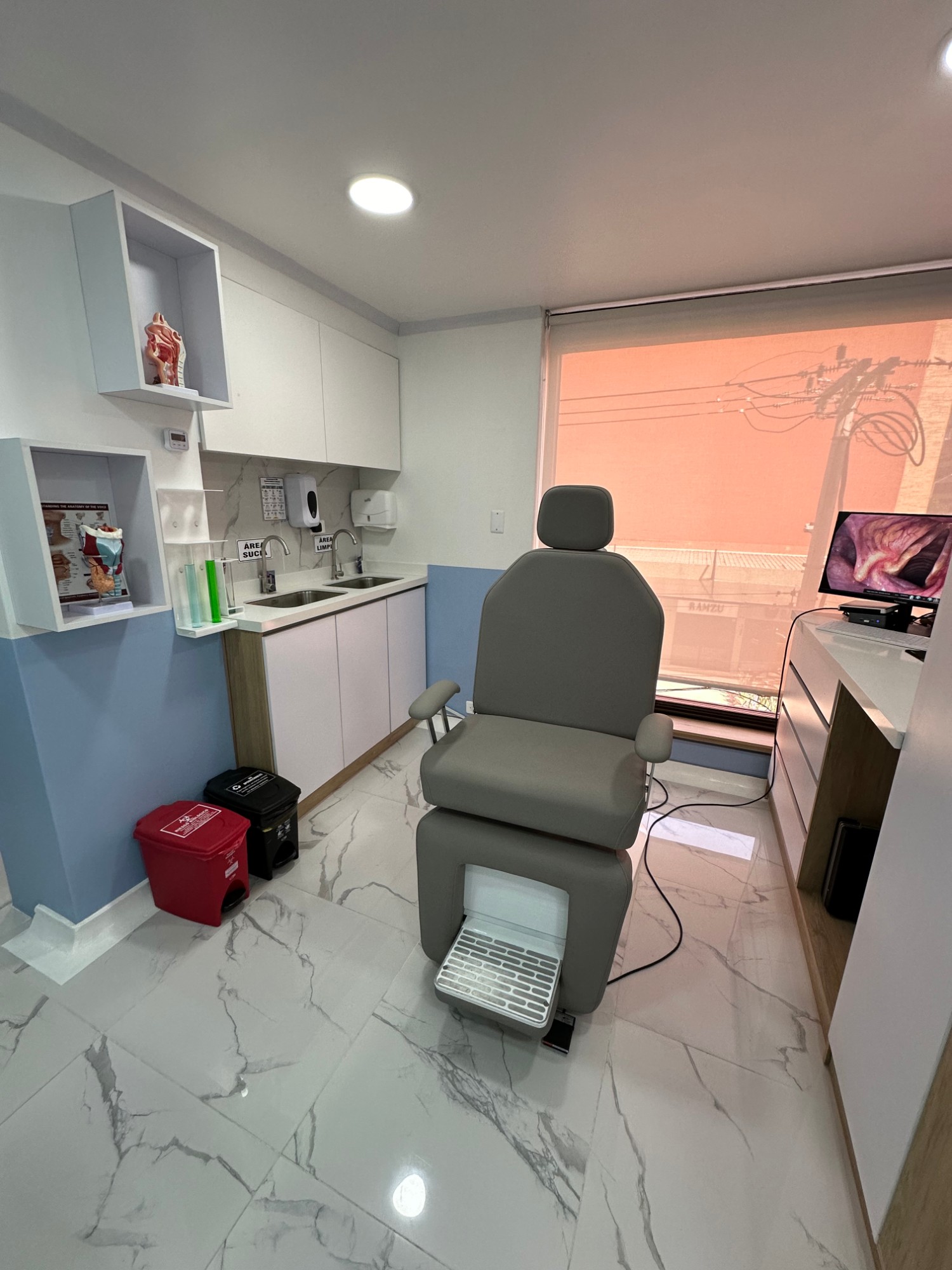 Sala de procedimientos con silla de exploración y equipo de endoscopia
